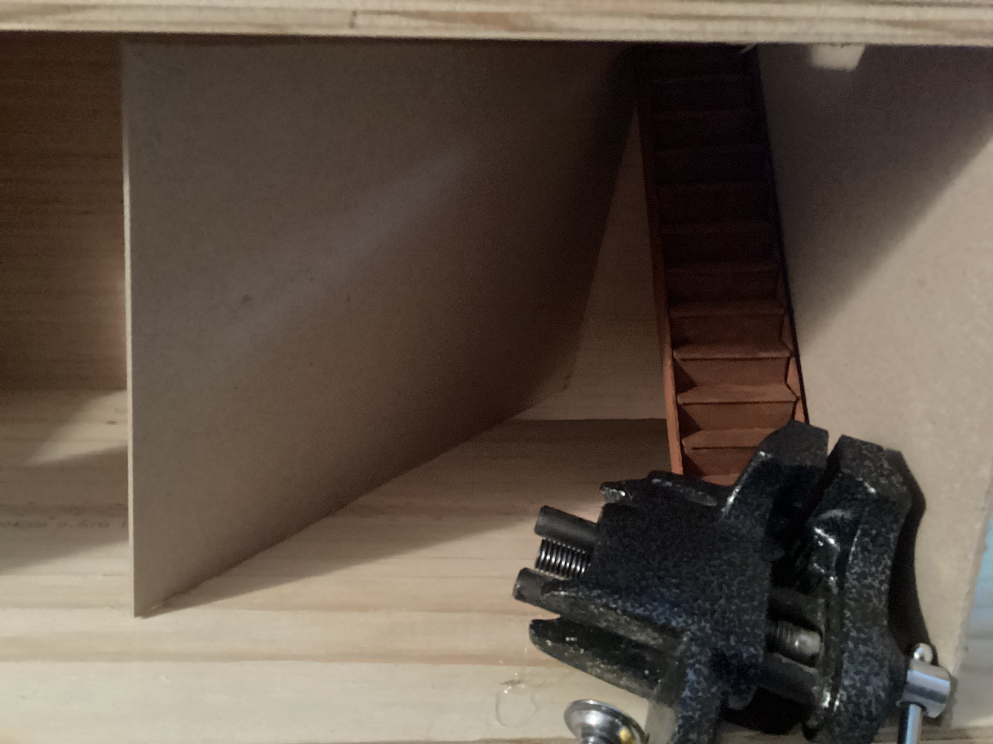 stairs held in place with friction fit board and heavy clamp laying on stairs